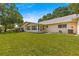 Landscaped backyard featuring a green lawn and yellow exterior at 8569 Sw 92Nd Ln # D, Ocala, FL 34481
