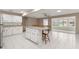 Open concept kitchen with white cabinetry, breakfast bar, and sunroom access at 8569 Sw 92Nd Ln # D, Ocala, FL 34481