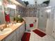 Bathroom with dual sinks, bathtub, glass-door shower, and unique floral wallpaper at 8765 Sw 190Th Cir, Dunnellon, FL 34432