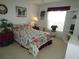 Bright bedroom features floral bedding, decor, and a large window with floral accents at 8765 Sw 190Th Cir, Dunnellon, FL 34432