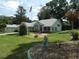Beautifully landscaped front yard with an angel statue and small bridge at 8765 Sw 190Th Cir, Dunnellon, FL 34432