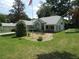 Professionally landscaped front yard with a decorative bridge and native plants at 8765 Sw 190Th Cir, Dunnellon, FL 34432