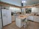 Spacious kitchen with white appliances, tile floors, and countertop seating at 8765 Sw 190Th Cir, Dunnellon, FL 34432
