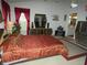 Main bedroom featuring red accents, a large bed, and mirrored dresser at 8765 Sw 190Th Cir, Dunnellon, FL 34432