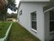 Exterior side yard view showing the home's siding, window, and lush green lawn at 8765 Sw 190Th Cir, Dunnellon, FL 34432