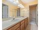 Bathroom featuring double sinks, wood cabinets, a walk-in shower, and ample counter space at 9093 Sw 91St Cir, Ocala, FL 34481