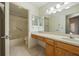 Bright bathroom with vanity, framed mirrors, and tub with shower at 9093 Sw 91St Cir, Ocala, FL 34481