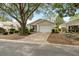 Charming single-story home with a well-maintained lawn, lush trees, and a brick-paved driveway at 9093 Sw 91St Cir, Ocala, FL 34481