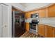 Modern kitchen featuring stainless steel appliances, wood floors, and oak cabinets at 9093 Sw 91St Cir, Ocala, FL 34481