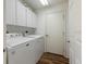 Bright laundry room featuring white appliances and cabinets with plenty of storage space at 9093 Sw 91St Cir, Ocala, FL 34481