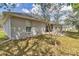 A backyard view of a single-story home with an open patio and well-maintained lawn at 9859 Sw 45Th Ave, Ocala, FL 34476