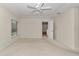 Spacious bedroom with a ceiling fan, window, neutral carpet and walls, with a walk-in closet and ensuite bath at 9859 Sw 45Th Ave, Ocala, FL 34476