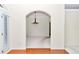 Open dining area view through an arched doorway, featuring a modern light fixture and neutral carpeting at 9859 Sw 45Th Ave, Ocala, FL 34476