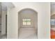 Dining area visible through an arched doorway, featuring neutral carpeting and a large window for natural light at 9859 Sw 45Th Ave, Ocala, FL 34476