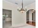 Dining room with ornate chandelier, open to the kitchen, with hardwood floors at 9859 Sw 45Th Ave, Ocala, FL 34476