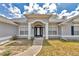 Inviting home entrance with classic white columns, stylish lighting fixtures, and elegant glass front door at 9859 Sw 45Th Ave, Ocala, FL 34476