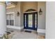 Close-up of the stylish, blue front door with sidelights, elegant lighting, and a welcoming entryway at 9859 Sw 45Th Ave, Ocala, FL 34476