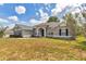 Beautiful home with blue shutters, featuring an open lawn area, and a charming front entryway at 9859 Sw 45Th Ave, Ocala, FL 34476