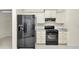 Bright kitchen with white cabinets and black appliances including a modern refrigerator and gas range at 9859 Sw 45Th Ave, Ocala, FL 34476