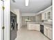 Bright eat-in kitchen with white cabinets, black appliances, tile floors and an opening into the dining area at 9859 Sw 45Th Ave, Ocala, FL 34476