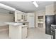 Open kitchen boasts a breakfast bar, white cabinets, black appliances, and pass-through to the dining area at 9859 Sw 45Th Ave, Ocala, FL 34476