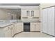 Corner kitchen featuring white cabinetry, a stainless-steel sink, a dishwasher, and a pantry cabinet at 9859 Sw 45Th Ave, Ocala, FL 34476