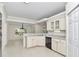 Bright kitchen featuring white cabinets, a breakfast bar, and a view into the sunny dining room at 9859 Sw 45Th Ave, Ocala, FL 34476