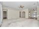 Open living room with ceiling fan and carpeted floors with archways leading to the entryway and other rooms at 9859 Sw 45Th Ave, Ocala, FL 34476