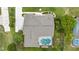 Aerial view of the property featuring a swimming pool, lush landscaping, and a well-maintained roof at 4966 Sw 107Th Loop, Ocala, FL 34476