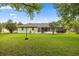 Spacious backyard featuring lush green grass, mature trees, and a screened-in lanai at 4966 Sw 107Th Loop, Ocala, FL 34476