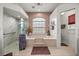 Bright bathroom featuring a tub, large window, and a glass-enclosed shower at 4966 Sw 107Th Loop, Ocala, FL 34476