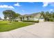 A charming one-story home, green exterior, manicured lawn, and long driveway at 4966 Sw 107Th Loop, Ocala, FL 34476