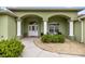 Inviting front porch with arched details, decorative columns, and lush landscaping at 4966 Sw 107Th Loop, Ocala, FL 34476