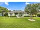 Charming one-story home with a well-manicured lawn, arched entryway, and lush landscaping at 4966 Sw 107Th Loop, Ocala, FL 34476