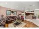 Inviting living room featuring hardwood floors, a comfortable leather sofa, and seamless flow to the kitchen at 4966 Sw 107Th Loop, Ocala, FL 34476