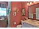 Charming bathroom with coral walls, decorative artwork, and a glass-enclosed shower at 7939 Se 12Th Cir, Ocala, FL 34480