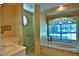Bright bathroom offering a walk-in shower, soaking tub, and natural light from the window at 7939 Se 12Th Cir, Ocala, FL 34480