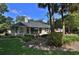 Charming single-story home with a well-manicured lawn, mature trees, and an inviting outdoor patio area at 7939 Se 12Th Cir, Ocala, FL 34480