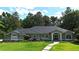 Attractive single-story home featuring a well-kept lawn, manicured garden beds, and an inviting entrance at 7939 Se 12Th Cir, Ocala, FL 34480