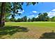 Expansive green lawn overlooking a picturesque golf course on a sunny day, perfect for outdoor recreation at 7939 Se 12Th Cir, Ocala, FL 34480