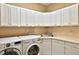 Well-organized laundry room featuring modern washer and dryer units with ample cabinet space at 7939 Se 12Th Cir, Ocala, FL 34480