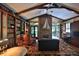 Spacious living room with a brick fireplace, exposed beams, and access to the outdoor patio at 7939 Se 12Th Cir, Ocala, FL 34480