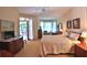Bright main bedroom offering a ceiling fan, bay window, and access to the outdoor patio at 7939 Se 12Th Cir, Ocala, FL 34480