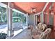 Relaxing screened patio features comfortable seating, a ceiling fan, and views of the landscaped yard at 7939 Se 12Th Cir, Ocala, FL 34480