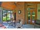 Inviting screened porch with brick fireplace, ceiling fan, and view of the beautifully landscaped outdoor space at 7939 Se 12Th Cir, Ocala, FL 34480