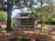Quaint home nestled among mature trees and shrubbery with a screened front porch and metal roof at 10805 Se 102Nd Pl, Ocala, FL 34472
