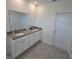 Bright bathroom featuring a double vanity with gray countertop and white cabinetry at 1114 Brimstone Cir, Winter Haven, FL 33884