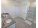 Bright bathroom featuring double sinks, a glass-enclosed shower, and neutral tile flooring at 1114 Brimstone Cir, Winter Haven, FL 33884
