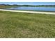 Exterior view of a community pond with a green lawn, and a sidewalk at 1114 Brimstone Cir, Winter Haven, FL 33884