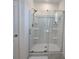 Modern shower with clear glass doors, built-in shelves, and sleek fixtures at 1114 Brimstone Cir, Winter Haven, FL 33884